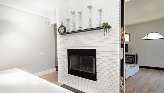 A picture of a white brick fireplace.