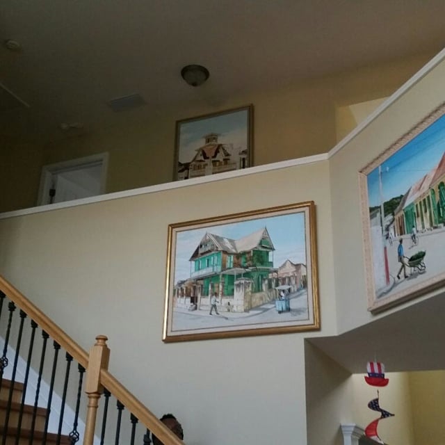 Paintings hanging on wall above the staircase.