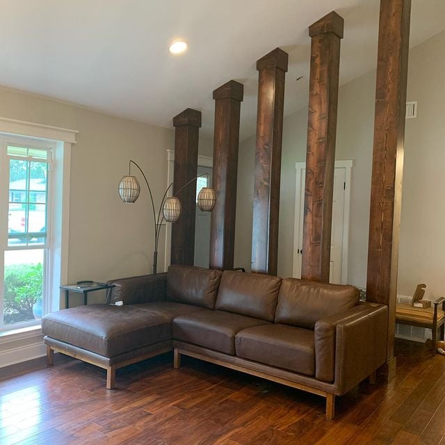 beige interior walls wooden stained pillar brown couch