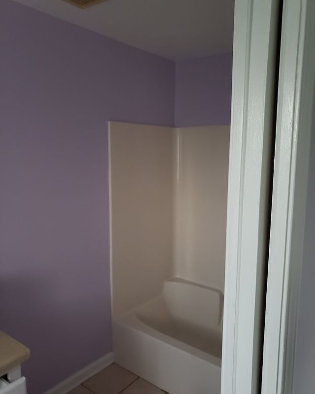 purple bathroom with white tub
