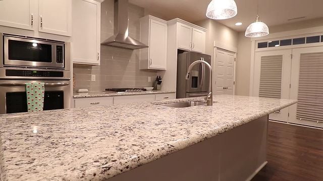 white kitchen cabinets and granite island