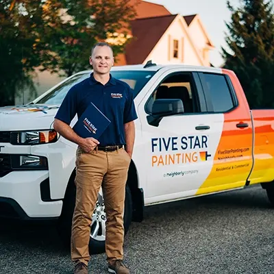 Five Star Painting professional standing beside branded van.
