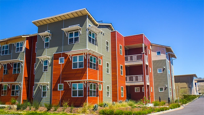 Gray and orange painted three story residential building.