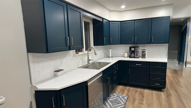 Dark blue cabinets in modern white kitchen.