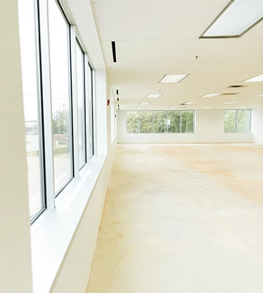 Large empty office space with tall windows.