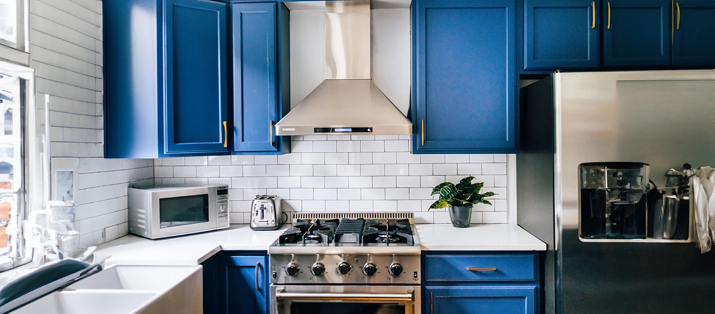 Modern kitchen with steel appliances and blue painted kitchen cabinets.