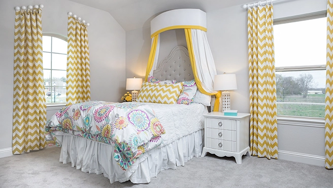 Bedroom with yellow chevon patterned curtains.