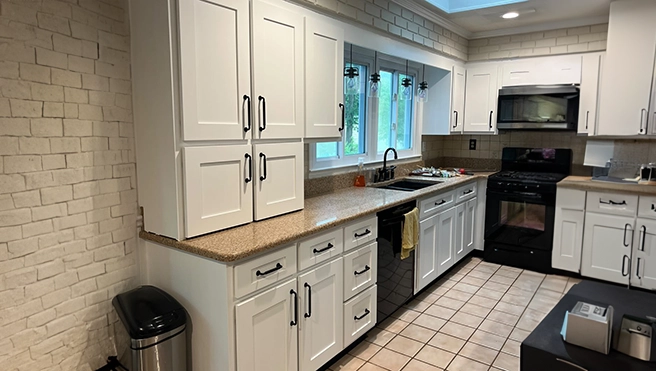 Modern kitchen with new white cabinets and granite countertop.