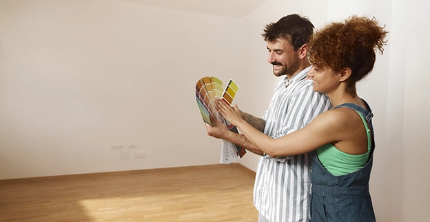 Smiling couple reviewing paint swatches.