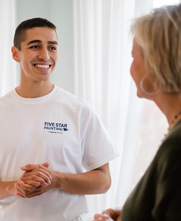 Smiling male painting professional conducting consultation with female customer.