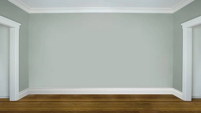 Empty room with seafoam green walls and newly installed baseboards.