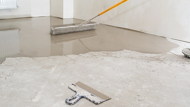 Coating a garage floor with a roller.