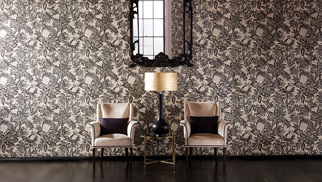 Black patterned wallpaper behind two chairs.