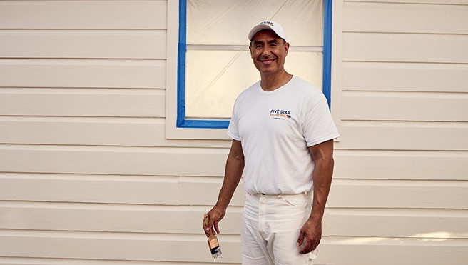 Five Star Painting worker outside a house.