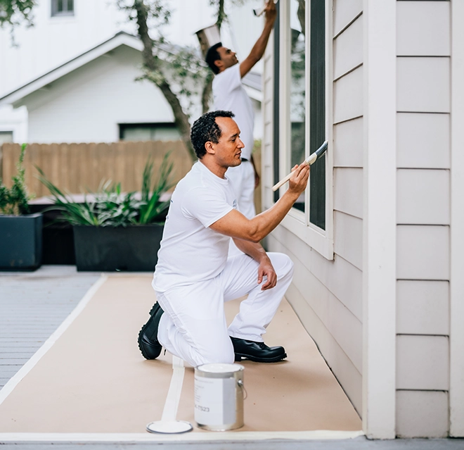 Painting professional painting the exterior of a home.
