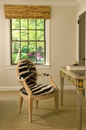 Faux zebra fur upholstered desk chair with neutral wood arms and legs.