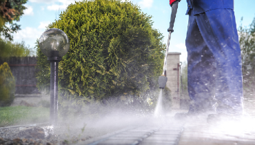 Blog title superimposed over a person pressure washing a wooden deck, Five Star Painting logo in the top right of the photo