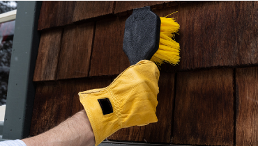 Person cleaning cedar shake siding