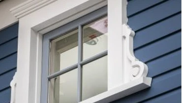 White framed window on a blue house
