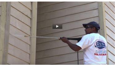 Photo of a Five Star Painting employee painting the outside of a house.