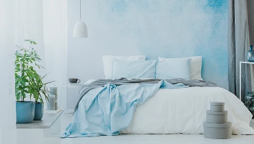 Photo of a bedroom with a blue and white accent wall.