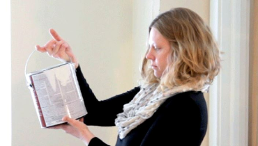 Photo of a pregnant woman staring at a paint can, Five Star Painting logo on the bottom left