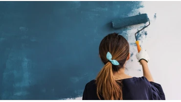 Lady painting wall.