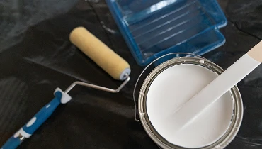 Painting materials and an open can of white paint