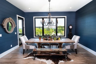 Photo of dining room with blue walls and wood table with white chairs