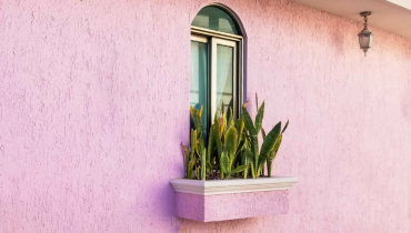 Pink stucco home with a window box.