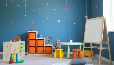 Modern playroom with toys and white easel. Stars hanging from the ceiling.